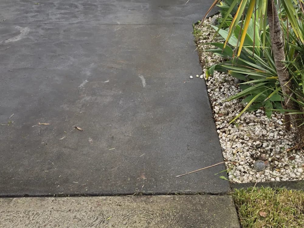 A cleaned concrete driveway and tidy garden border